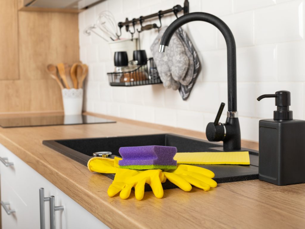 Kitchen sink with cleaning gloves and sponge