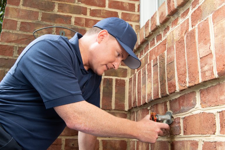 Technician inspecting outdoor spigot