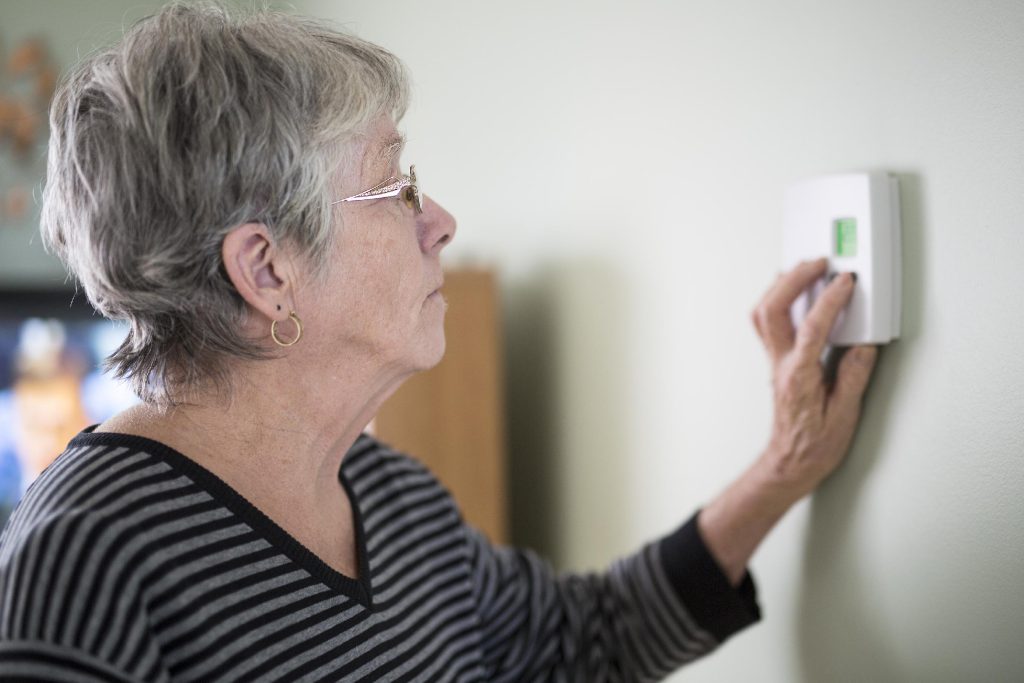 Woman adjusting thermostat